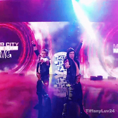 A Couple Of Men Standing On A Stage In Front Of A Screen That Says Mgm GIF