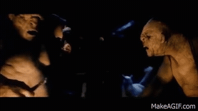 A Couple Of Monsters Standing Next To Each Other In The Dark . GIF