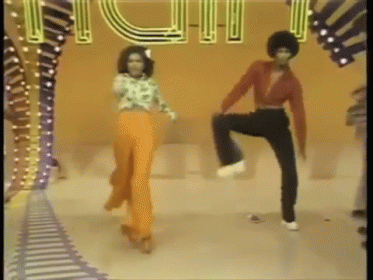 A Couple Of People Are Dancing In Front Of A Sign That Says ' Fun ' GIF