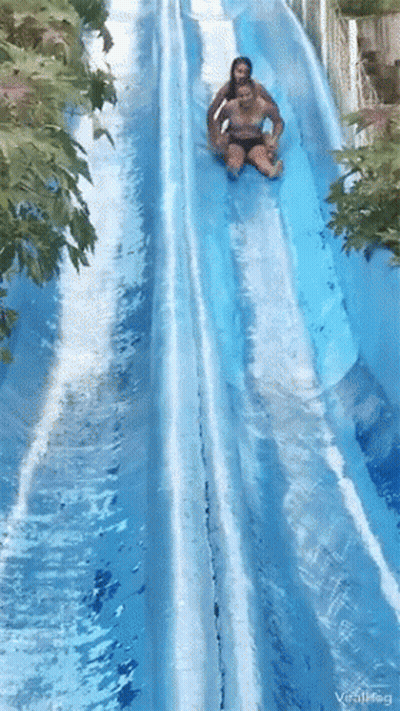 A Couple Of People Are Going Down A Water Slide At A Water Park .. GIF