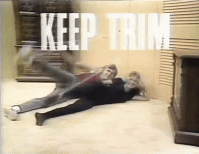 A Couple Of People Are Laying On The Floor In A Room With The Words `` Keep Trim '' Written On The Wall . GIF