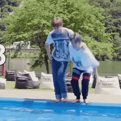 A Couple Of People Are Standing Next To Each Other In A Pool . GIF