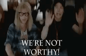 A Couple Of People Sitting Next To Each Other With Their Hands Up And The Words `` We 'Re Not Worthy ! '' GIF