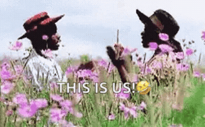 A Couple Of People Standing In A Field Of Purple Flowers . GIF