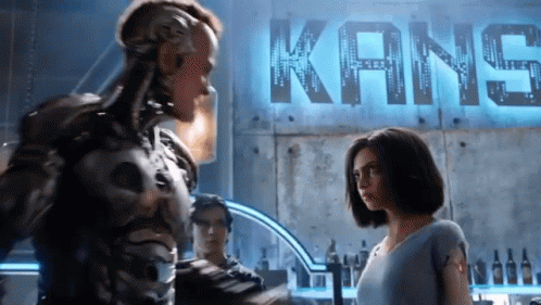 A Couple Of People Standing In Front Of A Kane Sign GIF