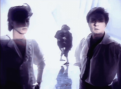 A Couple Of People Standing Next To Each Other In A White Room GIF