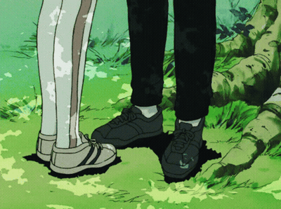 A Couple Of People Standing Next To Each Other With Their Feet In The Grass GIF