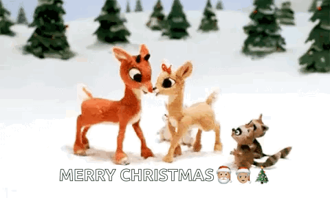 A Couple Of Stuffed Deer Standing Next To Each Other In The Snow With Trees In The Background . GIF