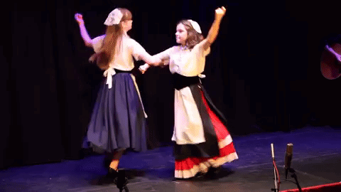 A Couple Of Women Are Dancing On A Stage . GIF