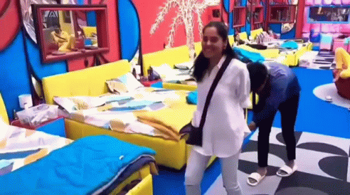 A Couple Of Women Are Standing Next To Each Other In A Bedroom . GIF