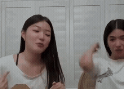 A Couple Of Women Are Standing Next To Each Other In A Room . GIF