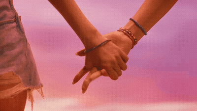 A Couple Of Women Holding Hands With Bracelets On Their Wrists GIF