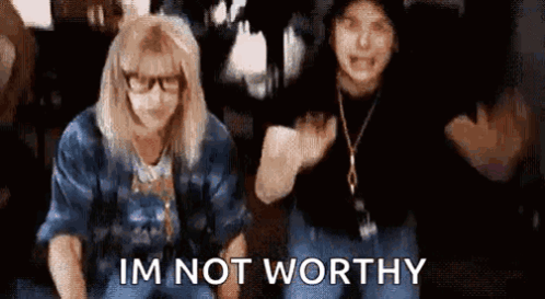 A Couple Of Women Sitting Next To Each Other With The Words `` I 'M Not Worthy '' Written On The Bottom . GIF
