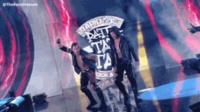 A Couple Of Wrestlers Are Standing In Front Of A Sign That Says Rapid Fire GIF