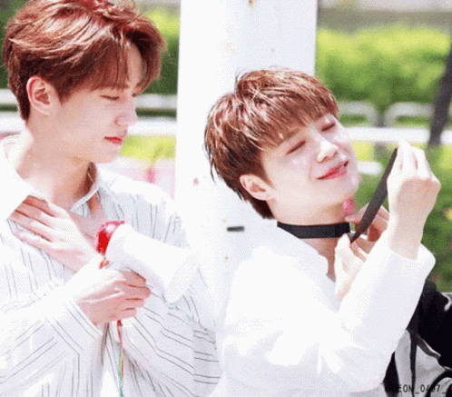 A Couple Of Young Men Are Standing Next To Each Other And One Of Them Is Wearing A Choker Around His Neck . GIF