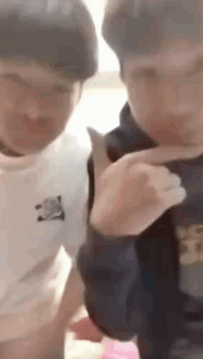 A Couple Of Young Men Are Standing Next To Each Other And Talking . GIF