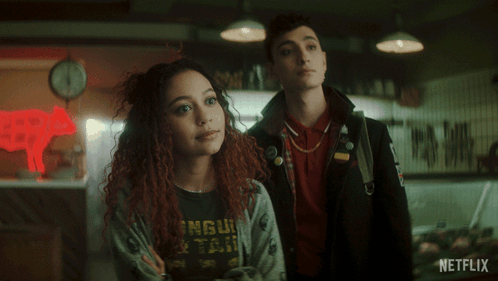 A Couple Standing In Front Of A Netflix Sign GIF