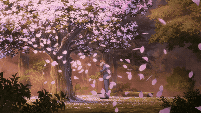 A Couple Standing Under A Tree With Petals Falling Around Them GIF