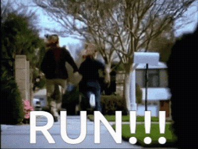 A Couple Walking Down A Street With The Word Run In White GIF