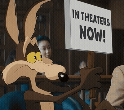 A Coyote Is Holding A Sign That Says In Theaters Now GIF