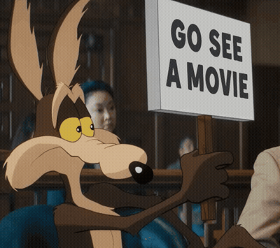 A Coyote Is Holding Up A Sign That Says Go See A Movie GIF