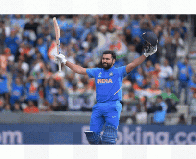 A Cricket Player Wearing A Blue India Jersey Holds His Bat In The Air GIF