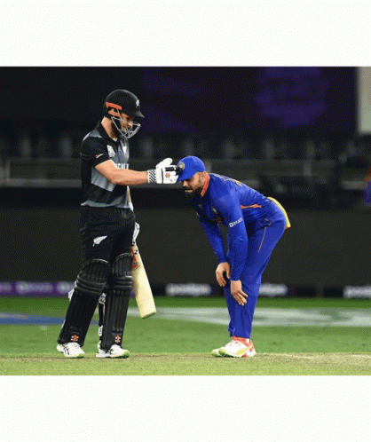 A Cricket Player Wearing A Blue Jersey That Says ' Deccan ' On It Talks To Another Player GIF