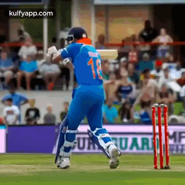A Cricket Player Wearing A Blue Jersey With The Number 13 On It Is Running Towards The Wicket . GIF