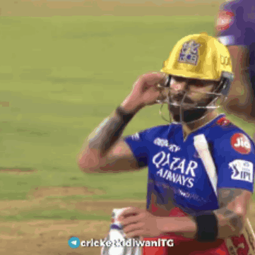 A Cricket Player Wearing A Helmet And A Qatar Airways Shirt GIF
