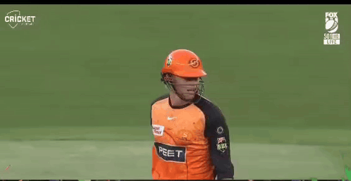 A Cricket Player Wearing A Helmet And Holding A Bat On A Field GIF
