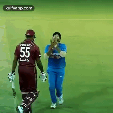 A Cricket Player Wearing A Jersey With The Number 55 On It Is Walking Towards Another Player . GIF