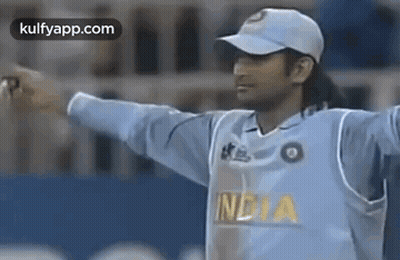 A Cricket Player Wearing A White Hat And A Blue Jersey Is Standing On A Field . GIF