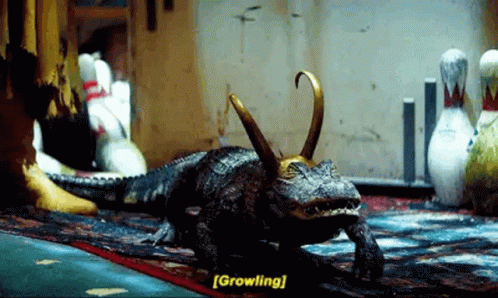 A Crocodile With A Crown On Its Head Is Walking On A Rug In A Bowling Alley . GIF