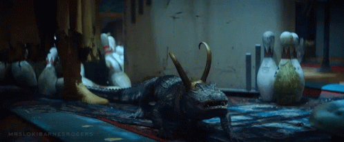 A Crocodile With Horns Is Standing In A Room With Bowling Pins GIF