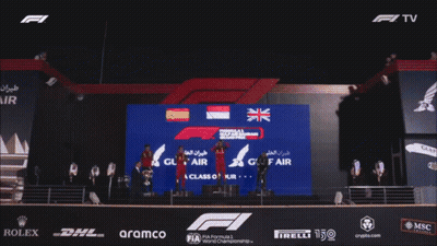 A Crowd Of People Applauding In Front Of A Fence That Says Class Of Ducrown GIF