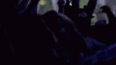A Crowd Of People Are Dancing At A Concert And Their Hands Are In The Air . GIF
