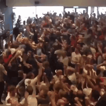 A Crowd Of People Are Dancing In A Room GIF