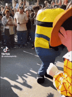 A Crowd Of People Are Gathered Around A Toy Story Character GIF