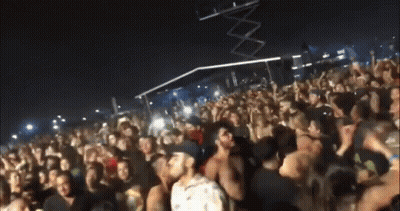 A Crowd Of People Are Gathered At A Concert And One Man Is Standing In The Middle Of The Crowd GIF
