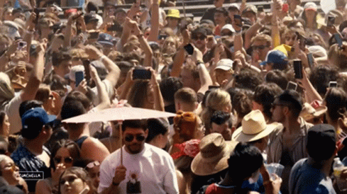 A Crowd Of People Are Gathered At A Music Festival With A Sign That Says Palm Springs On It GIF