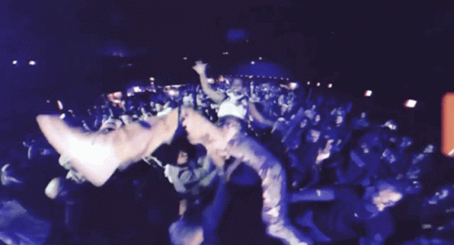 A Crowd Of People Are Gathered In A Dark Room With A Red Sign That Says ' A ' On It GIF