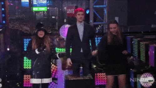 A Crowd Of People Are Gathered In A Dark Room With A Sign That Says Oh Call Me Yes ! GIF