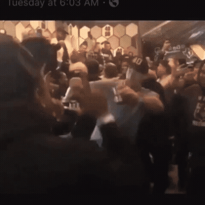 A Crowd Of People Are Gathered In A Room With The Time Of 6:03 GIF