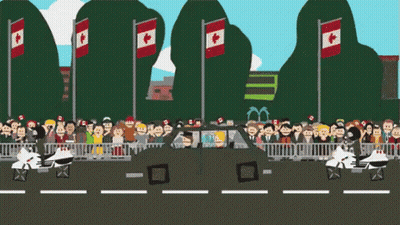 A Crowd Of People Are Gathered In Front Of A Car With Canadian Flags On The Poles GIF