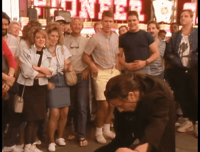 A Crowd Of People Are Gathered In Front Of A Sign That Says ' Showcase ' GIF
