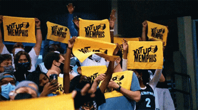 A Crowd Of People Are Holding Up Yellow Signs That Say ' Xtup Memphis ' GIF