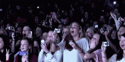 A Crowd Of People Are Taking Pictures With Their Cell Phones At A Concert . GIF