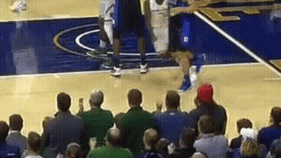 A Crowd Of People Are Watching A Basketball Game On A Basketball Court . GIF
