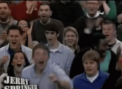 A Crowd Of People Are Watching A Game And One Of Them Is Holding A Sign That Says Jerry Siddinger GIF
