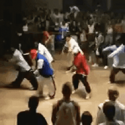 A Crowd Of People Are Watching A Group Of People Dancing In A Room . GIF